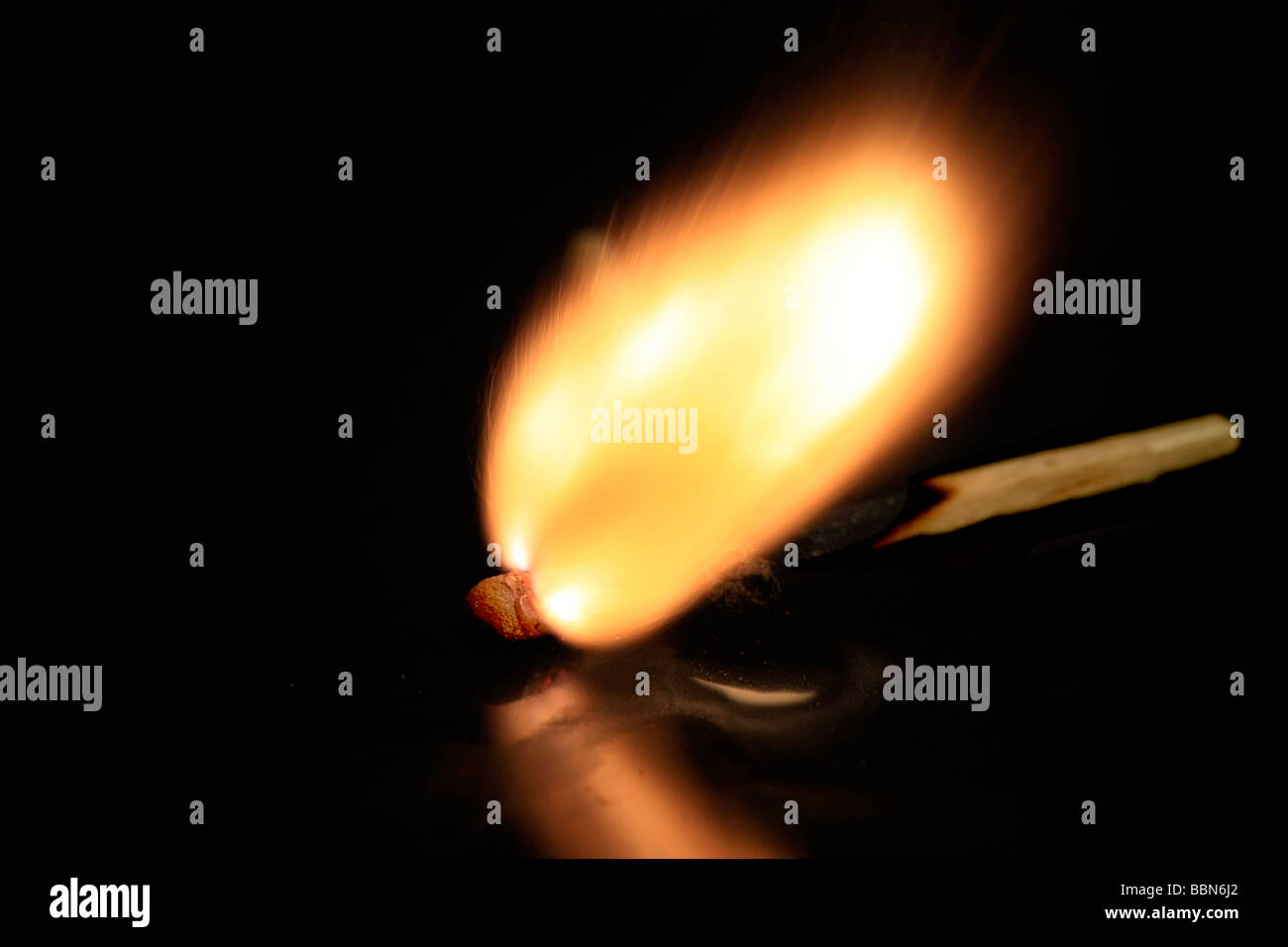 A match stick on fire, on a black reflective surface Stock Photo Alamy