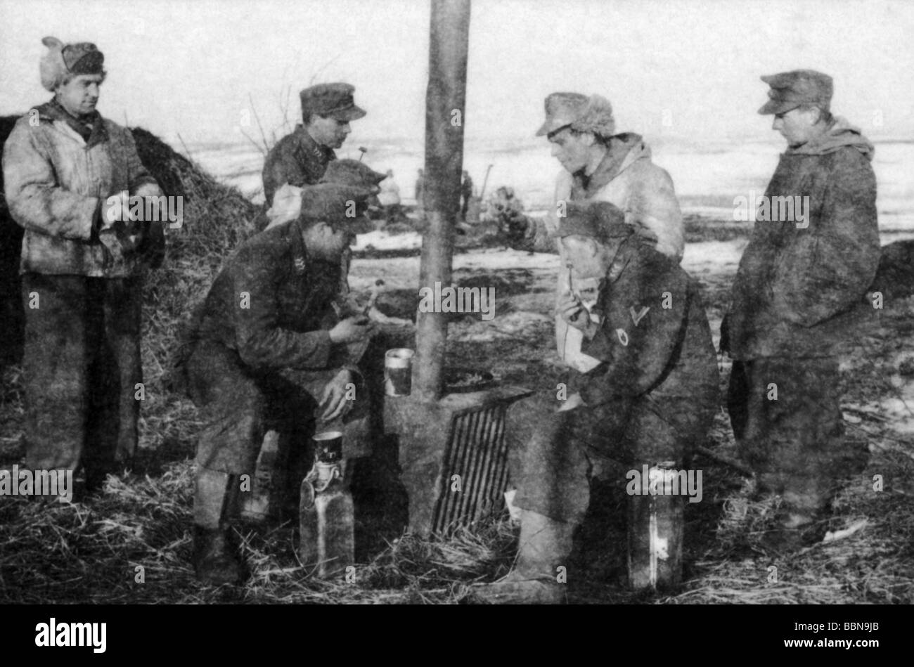 events, Second World War / WWII, Russia 1944 / 1945, German soldiers with a self-made stove, near Britskoye, Ukraine, late January 1944, Eastern Front, historic, historical, winter, snow, USSR, Soviet Union, 20th century, historic, historical, winter clothes, Wehrmacht, Luftwaffe, warming up, 1940s, people, Stock Photo