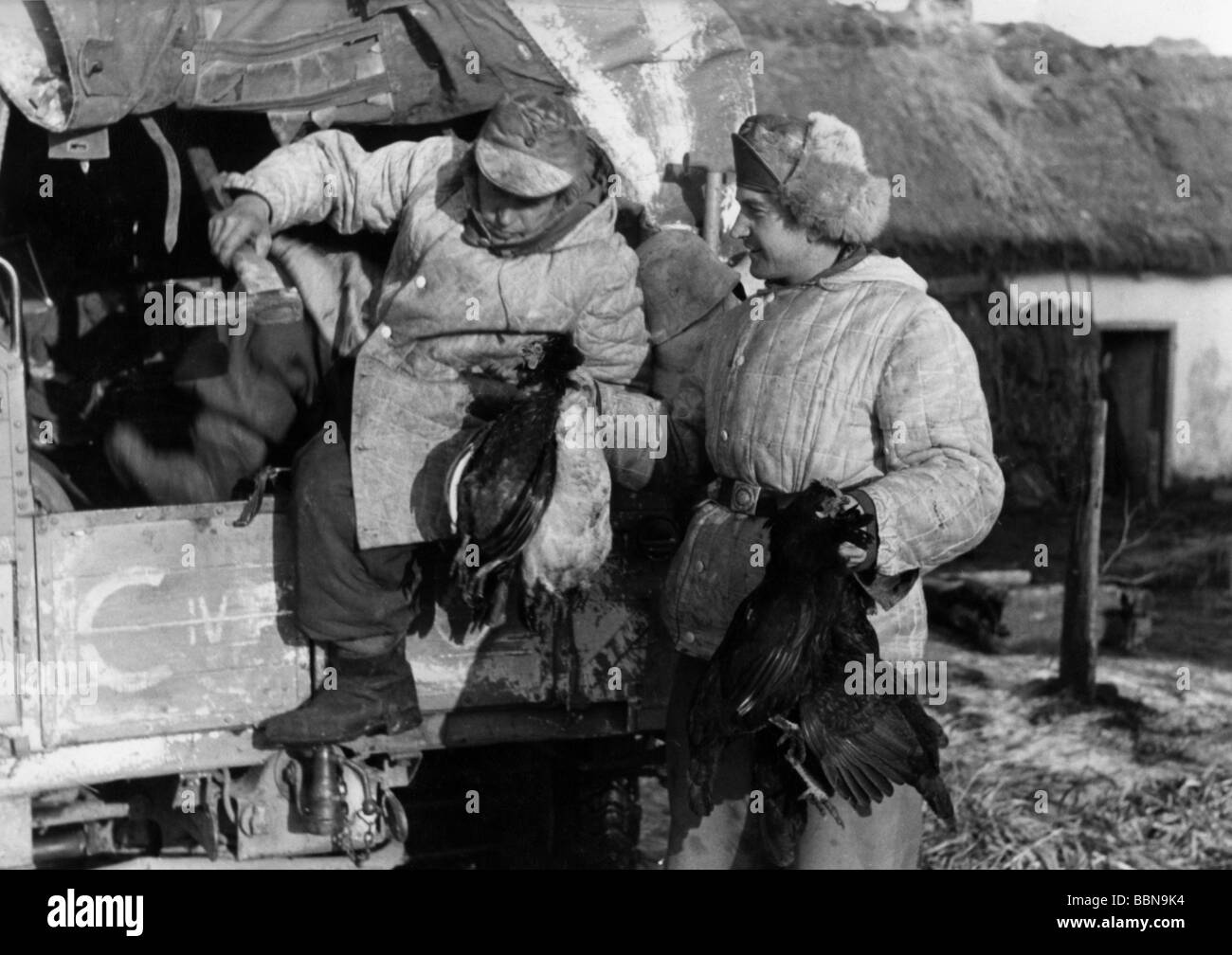events, Second World War / WWII, Russia 1944 / 1945, German soldiers in the captured village of Britskoye, Ukraine, with caught chickens, 24.1.1944, Wehrmacht, Eastern Front, Soviet Union, USSR, 20th century, historic, historical, Third Reich, winter clothing, lorry, axe, people, 1940s, Stock Photo