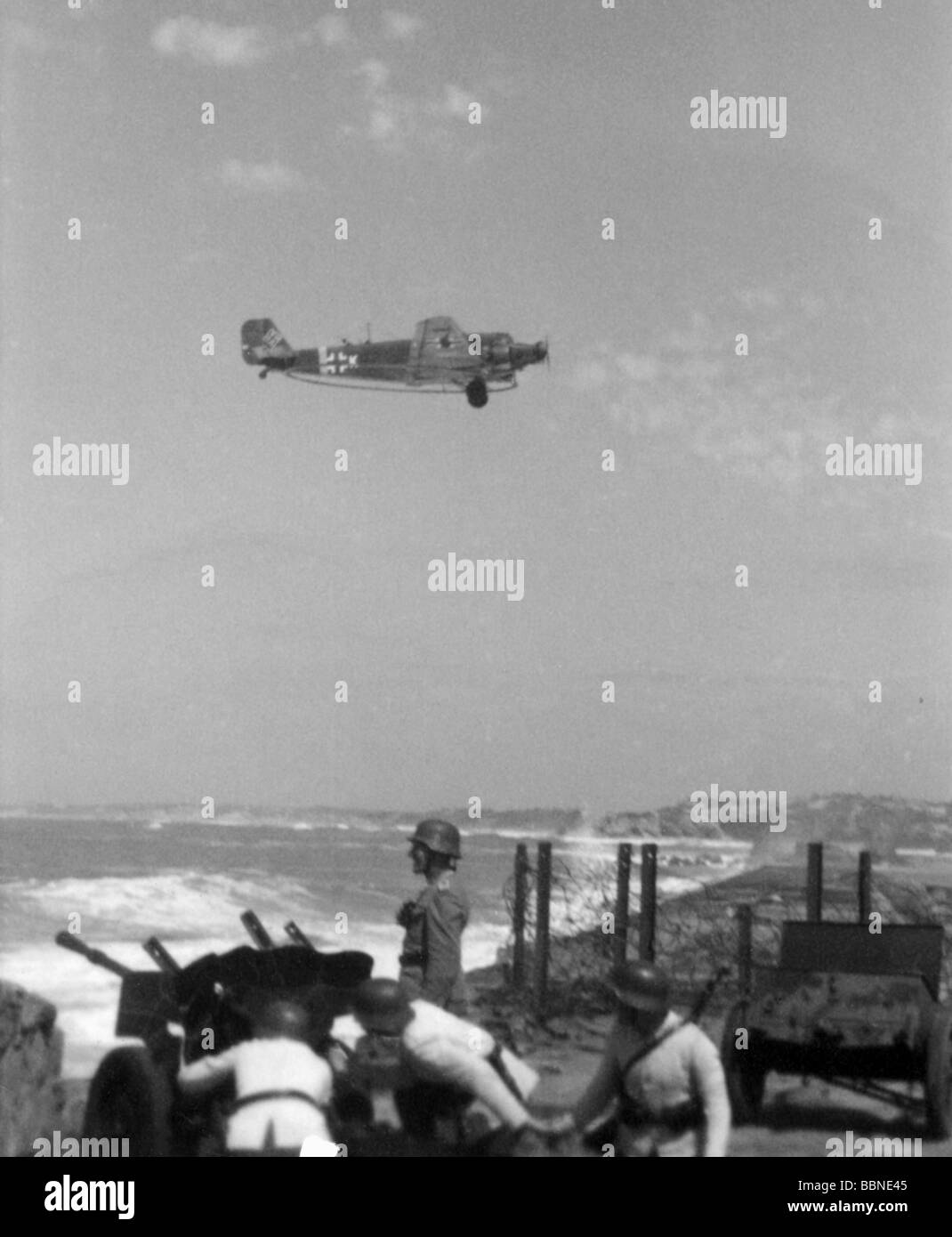 events, Second World War / WWII, France, Atlantic Wall, German minesweeper plane Junkers Ju 52 MS flying over the French west coast near Biarritz, in the foreground an anti-tank gun crew exercising, 28.4.1943, Stock Photo