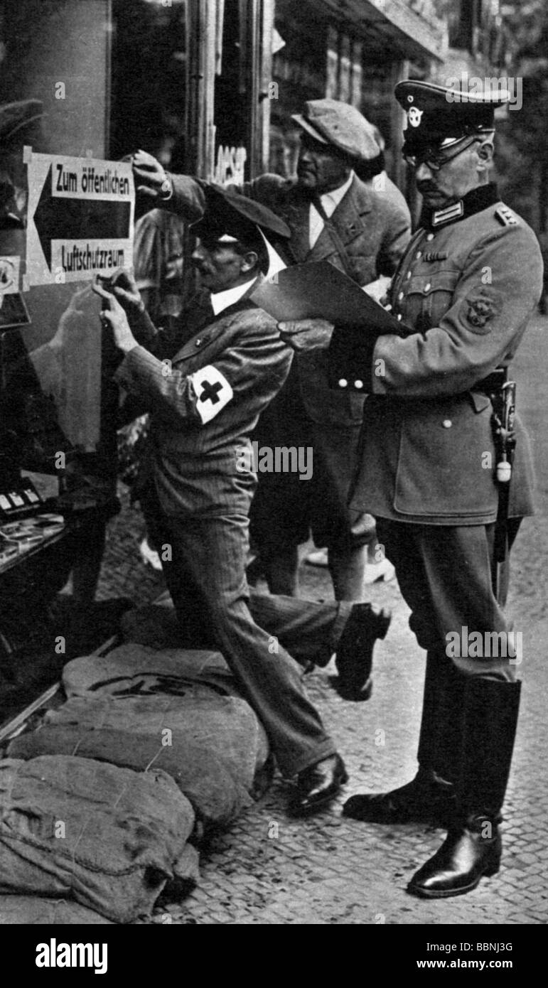 events, Second World War / WWII, aerial warfare, Germany, police officer and German Red Cross aides attaching a direction sign indicating the public air raid shelter, Berlin, late August 1939, Stock Photo