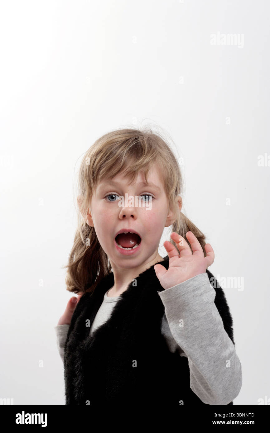 young girl with an expression of shock wearing a gilet or mock fur jacket Stock Photo