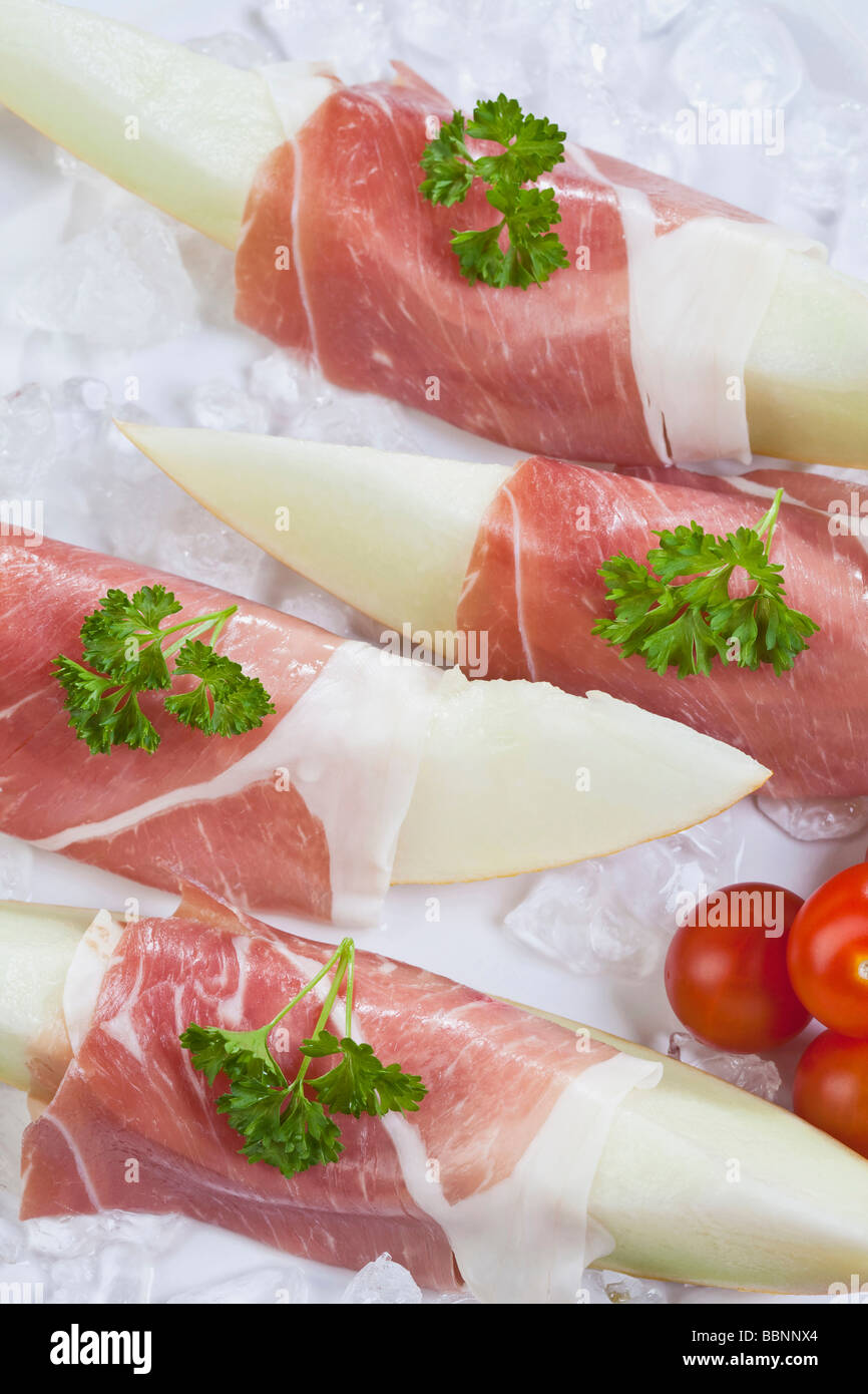 Melon slices with Parma ham on crushed ice Stock Photo