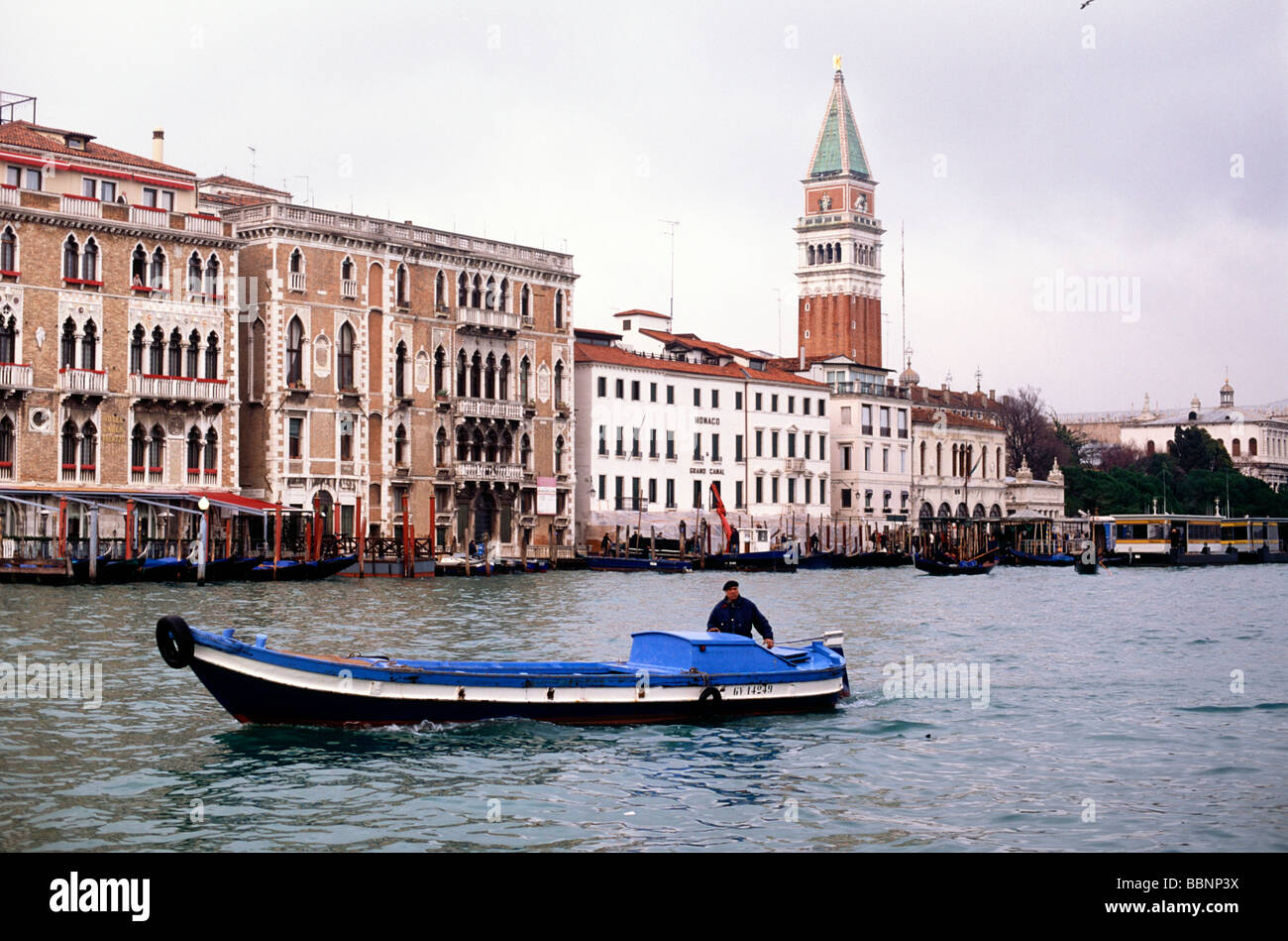 Man navigating his boat up the Grand Canal in Venice Stock Photo - Alamy