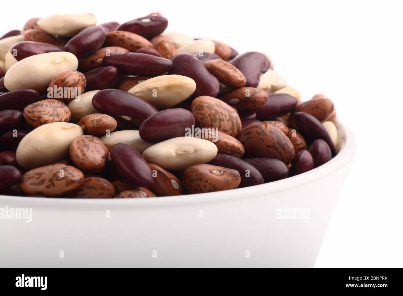 Various bean types in white bowl isolated on white Stock Photo