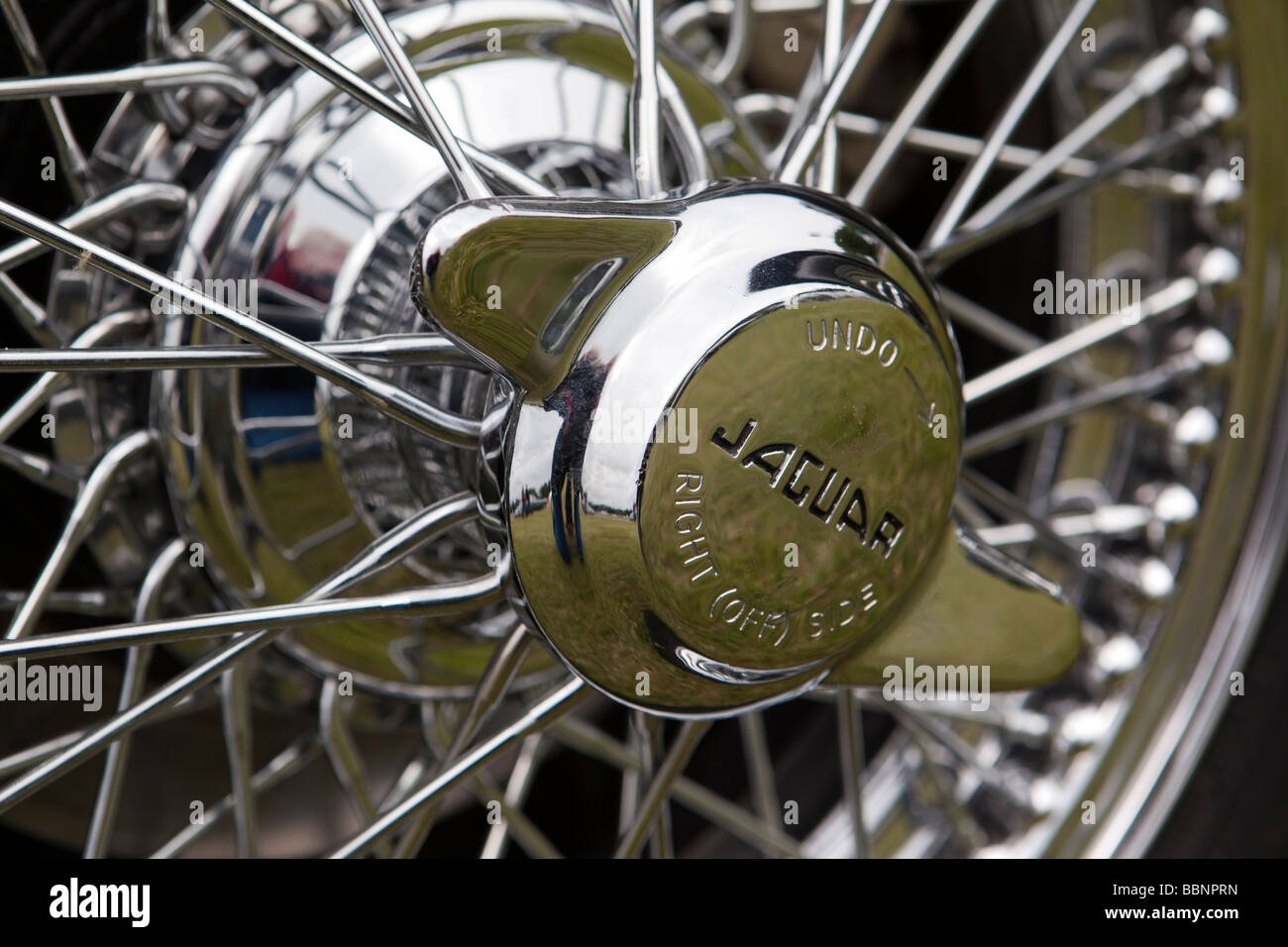 Motoring chromed wheel spinner on wire wheel of classic 1950s Jaguar XK140 sports car Stock Photo