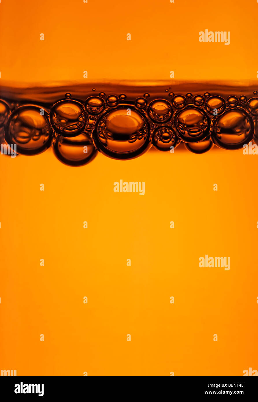close up of bubbles at the top of a beer bottle Stock Photo