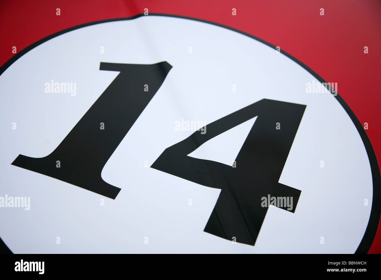 Number 14 in white circle on red background. Stock Photo