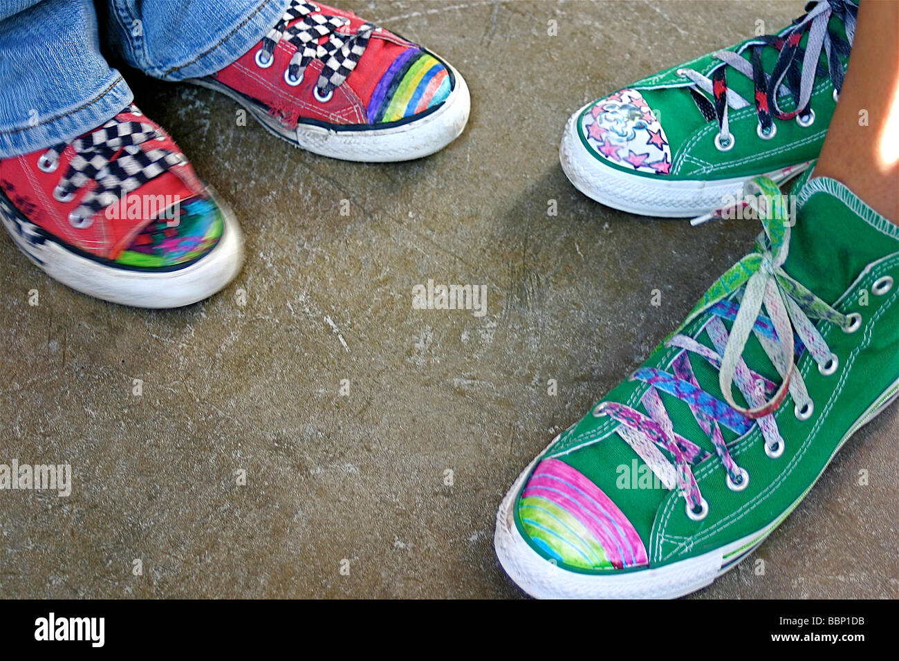 Just hanging around.  Two teenagers with their hand painted tennis shoes Stock Photo
