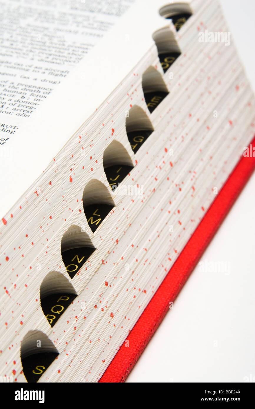 Close up of dictionary with gold lettered tabs and page text against white background, selective focus Stock Photo