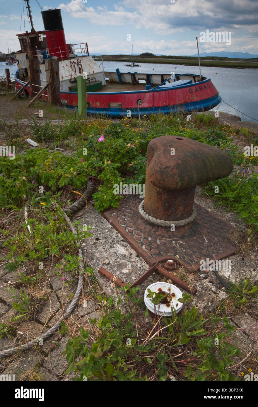 Disused fishing boat tied up at pier with rusty capstan and chains at Irvine Ayrshire Scotland Stock Photo