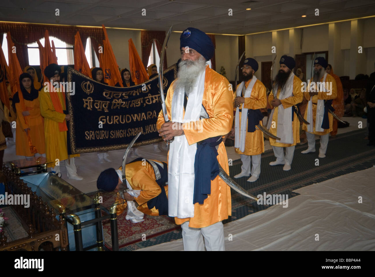 Sikhs in the worship hall at Hounslow Gurdwara for Vaisakhi celebrations . The Panj Pyare bow to the Guru Granth Sahib Stock Photo