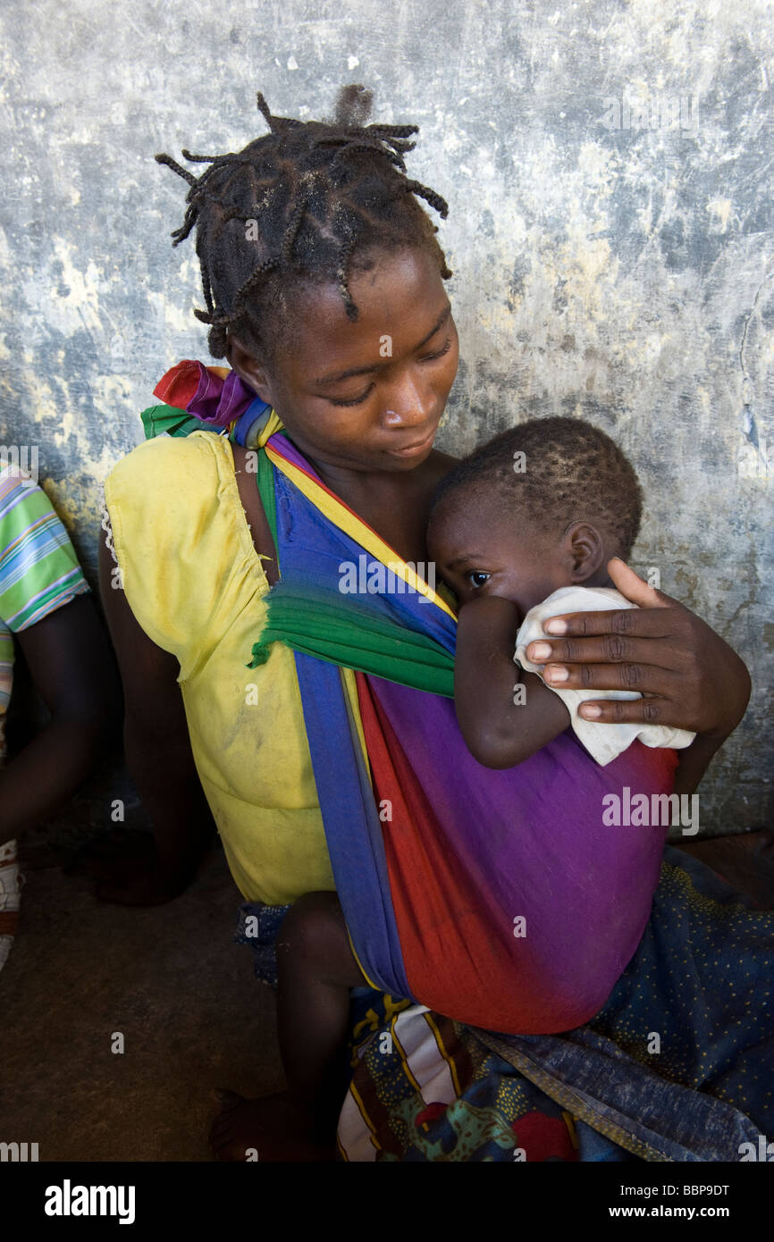 A woman carrying a child attends a HIV AIDS awareness campaign Quelimane Mozambique Stock Photo