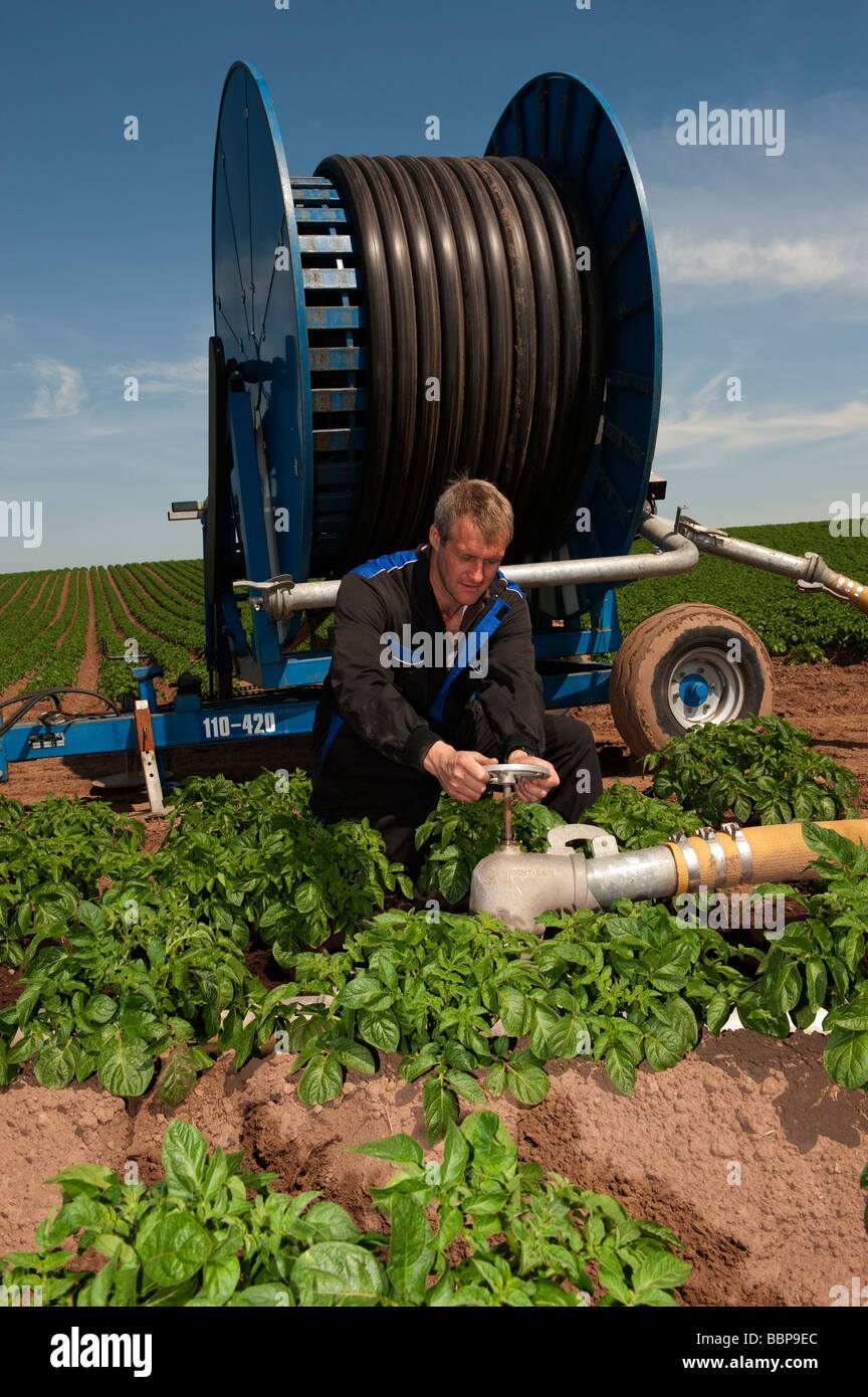 Farmer turning stopcock on a waterwheel travelling irrigation system