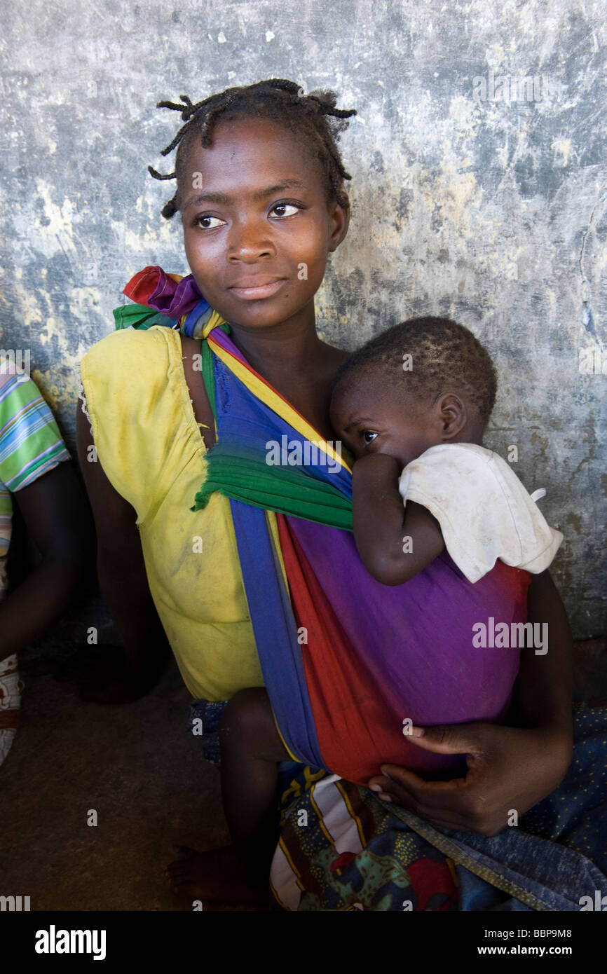A woman carrying a child attends a HIV AIDS awareness campaign Quelimane Mozambique Stock Photo