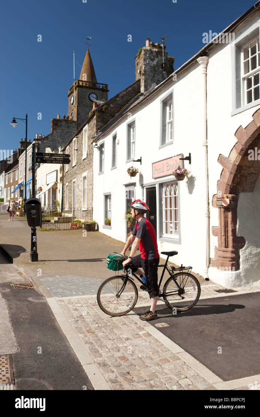 Cyclist poseing below the Pend leading up to Whithorn Priory in picturesque Whithorn town centre Galloway Scotland UK Stock Photo