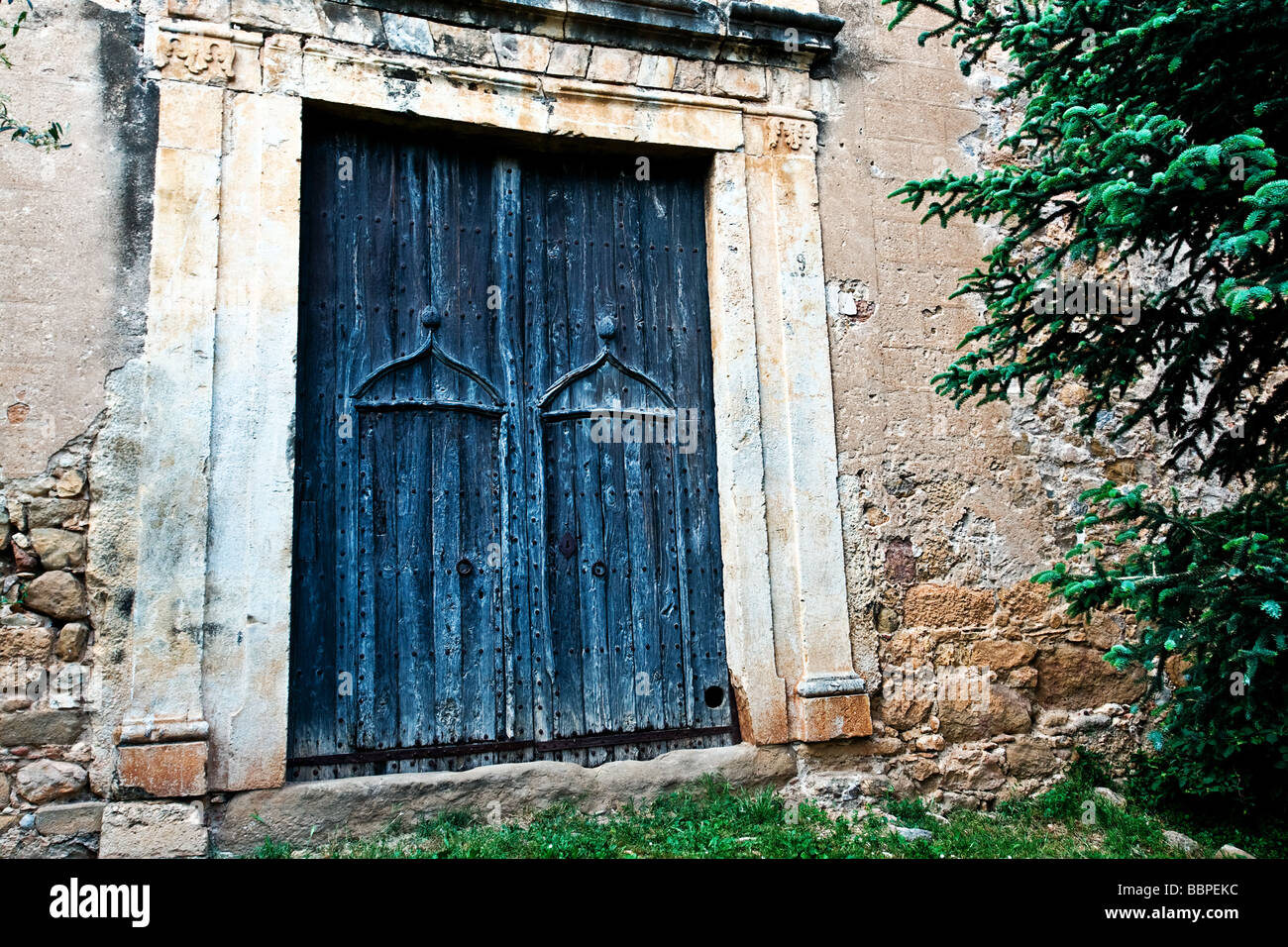 Aold wooden door with Romanesque Gothic design in the village of Llado, Northern Spain. Stock Photo