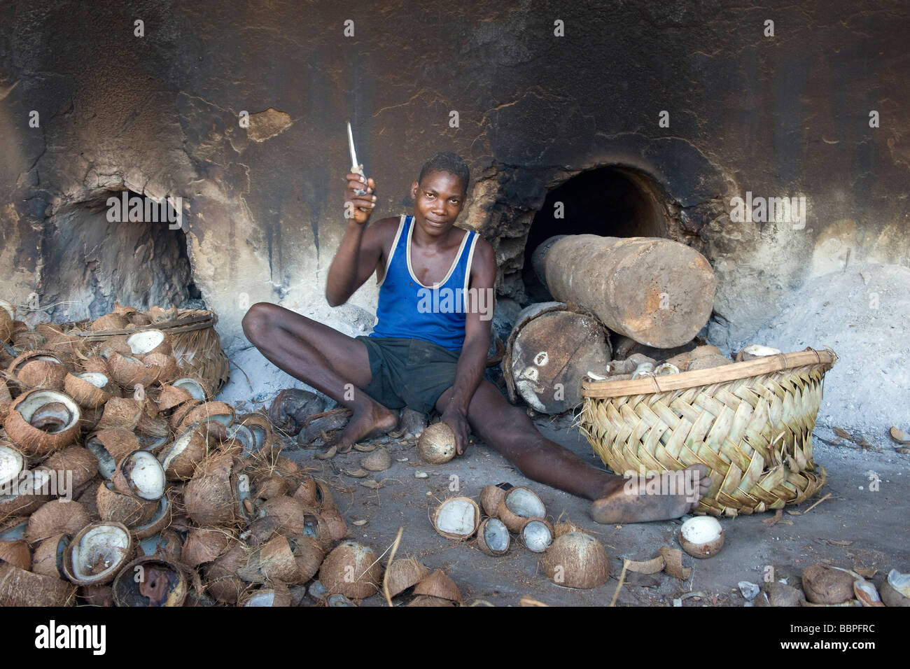 A boy removes the dried meat or kernel called copra from the coconut