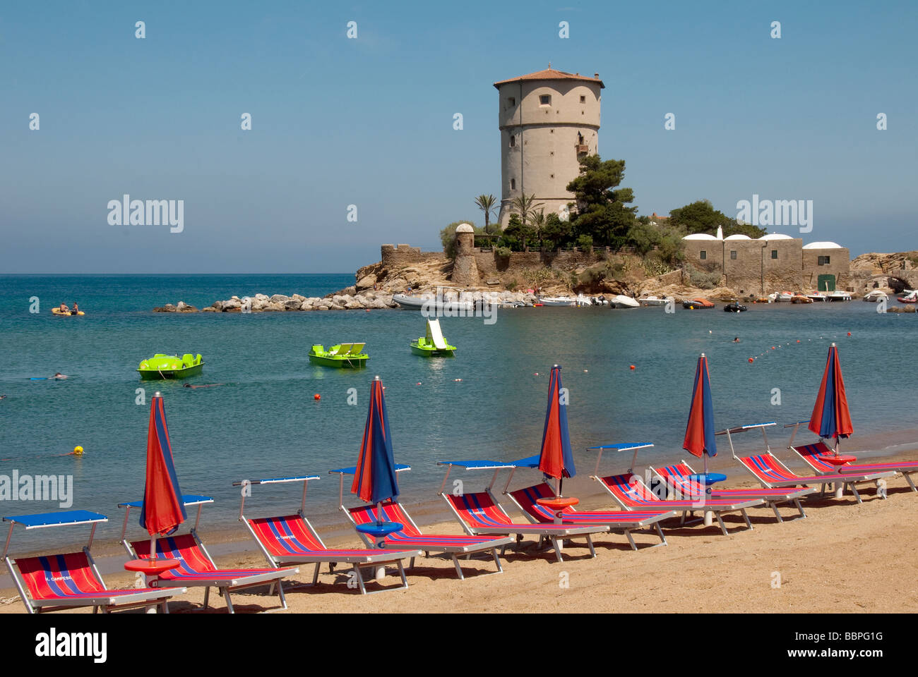 Umbrellas and sunbeds at Giglio Campese the main beach on the Island of Giglio or Isola del Giglio off the Tuscan coast Stock Photo