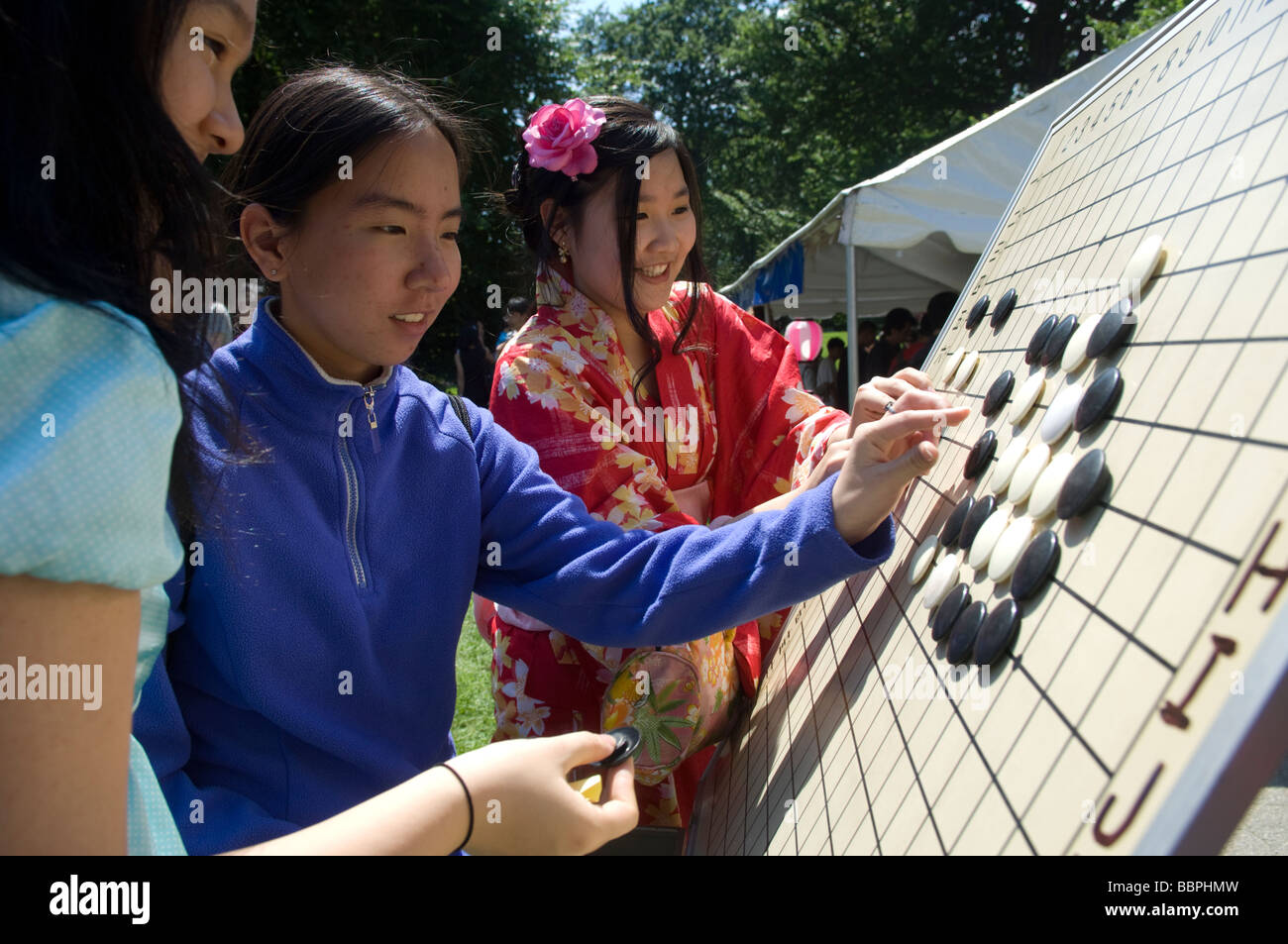 Girls check out a Japanese board game called Go or Japanese checkers Stock Photo