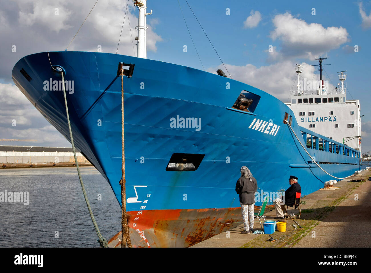 LINE FISHERMEN IN FRONT OF A DOCKED CARGO BOAT IN THE COMMERCIAL PORT, LE HAVRE, SEINE-MARITIME (76), NORMANDY, FRANCE Stock Photo