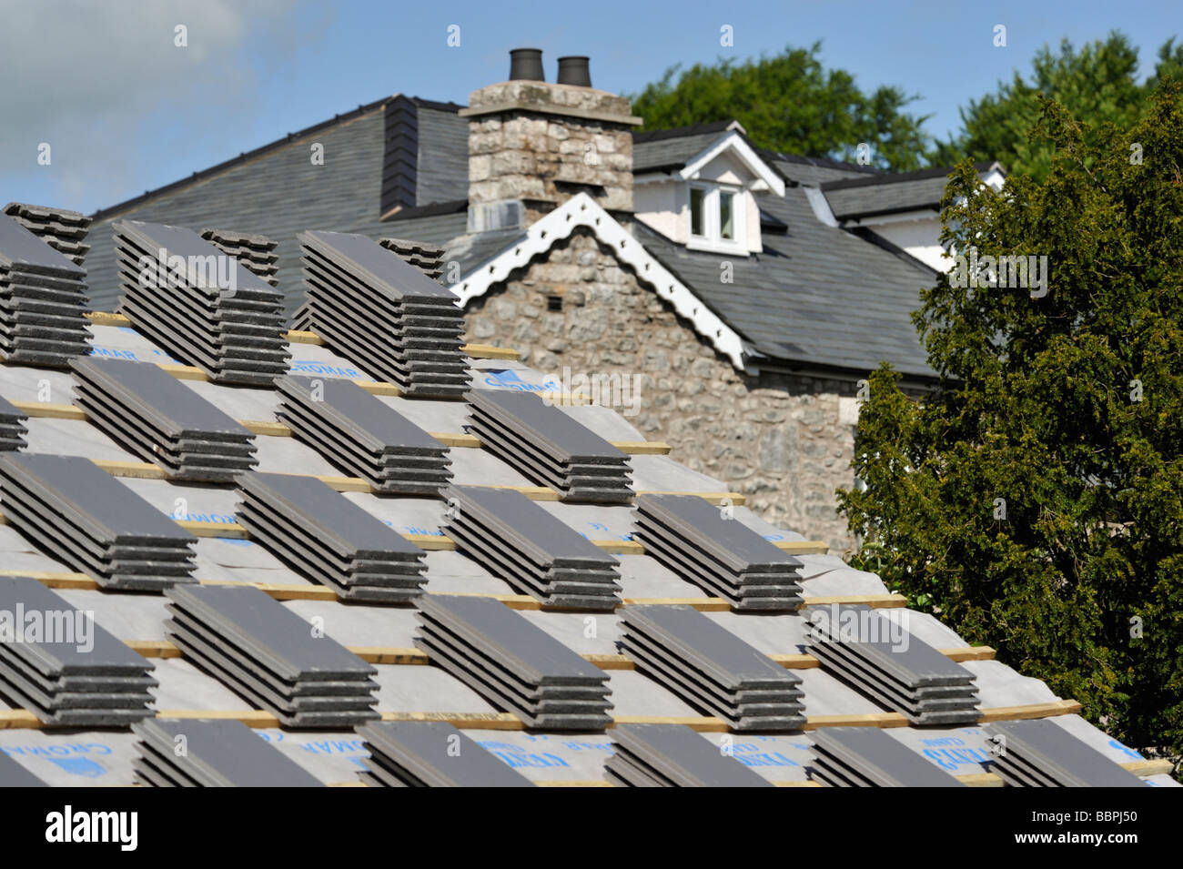 Roofing slates, stacked on roof, prior to re-roofing house. Stock Photo