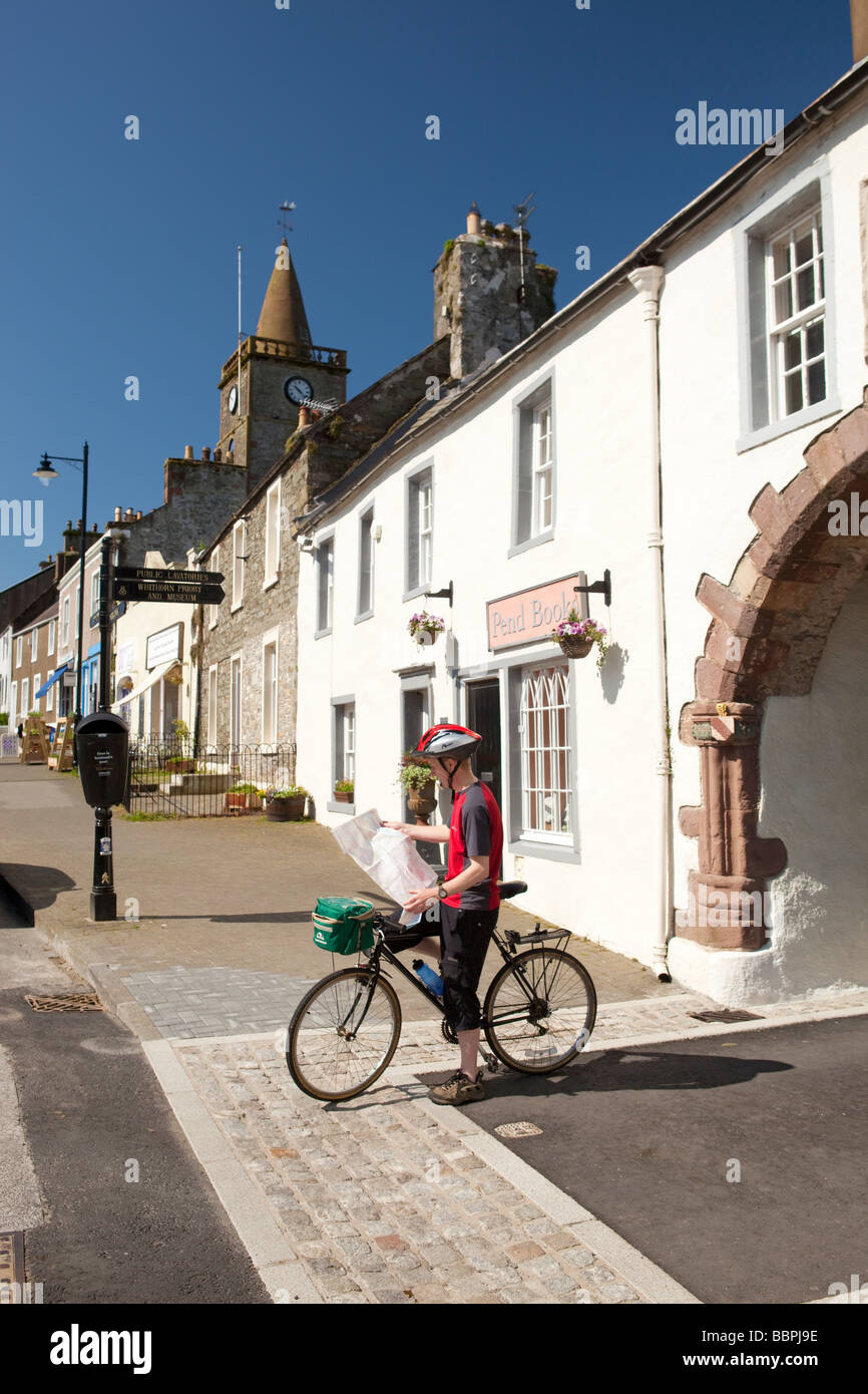 Cycling picturesque town centre Whithorn cyclist looking at map at the Pend leading up to Whithorn Priory Galloway Scotland UK Stock Photo