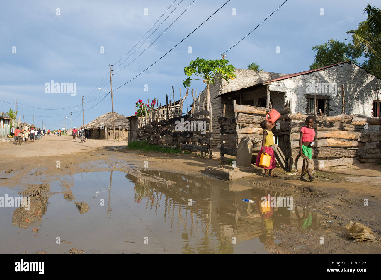 Road with water filled potholes provide breeding grounds for Malaria mosquitoes Quelimane Mozambique Stock Photo