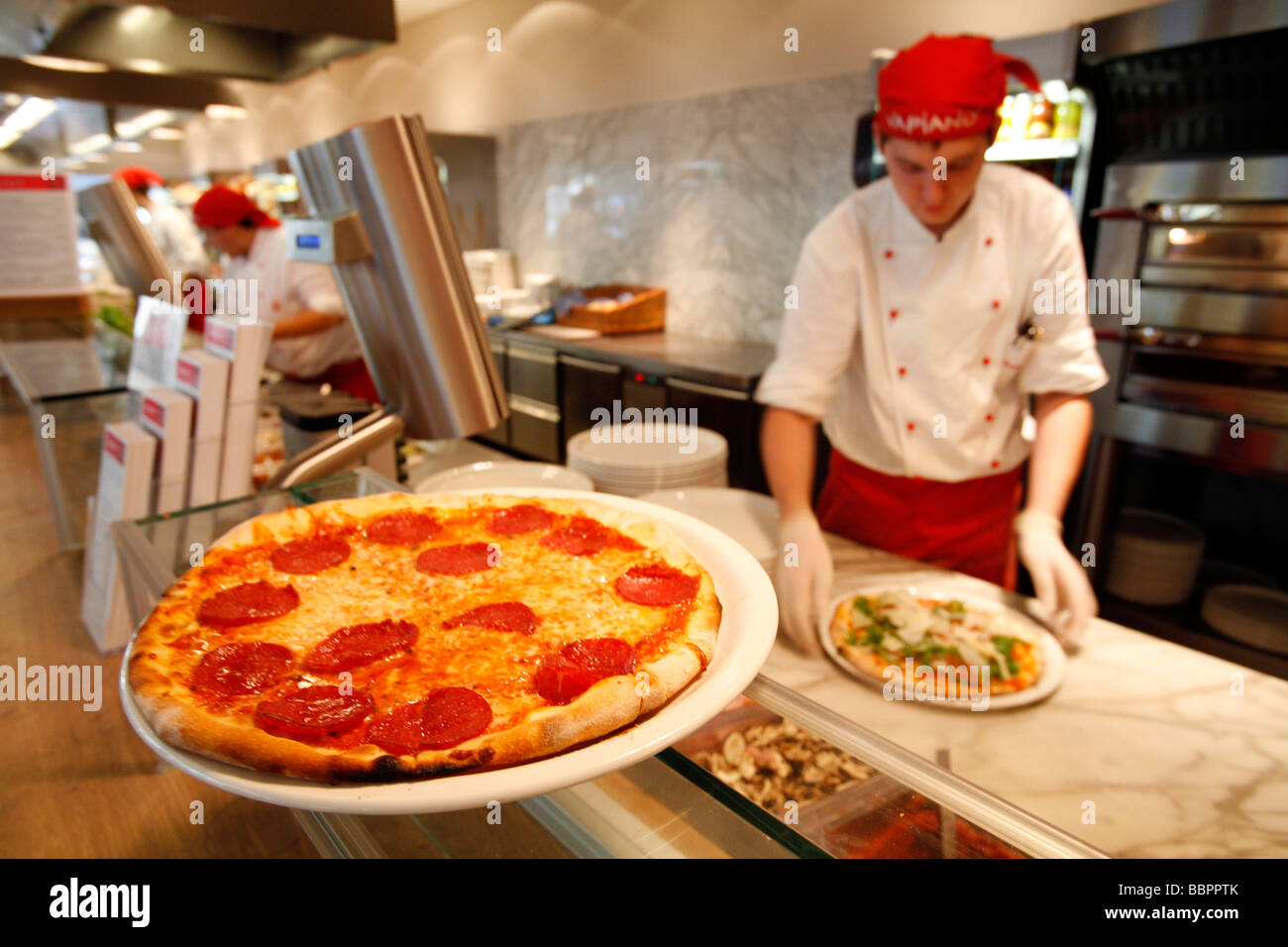 PIZZA-MAKER AND PIZZA, ITALIAN RESTAURANT VAPIANO, VIENNA, AUSTRIA Stock Photo