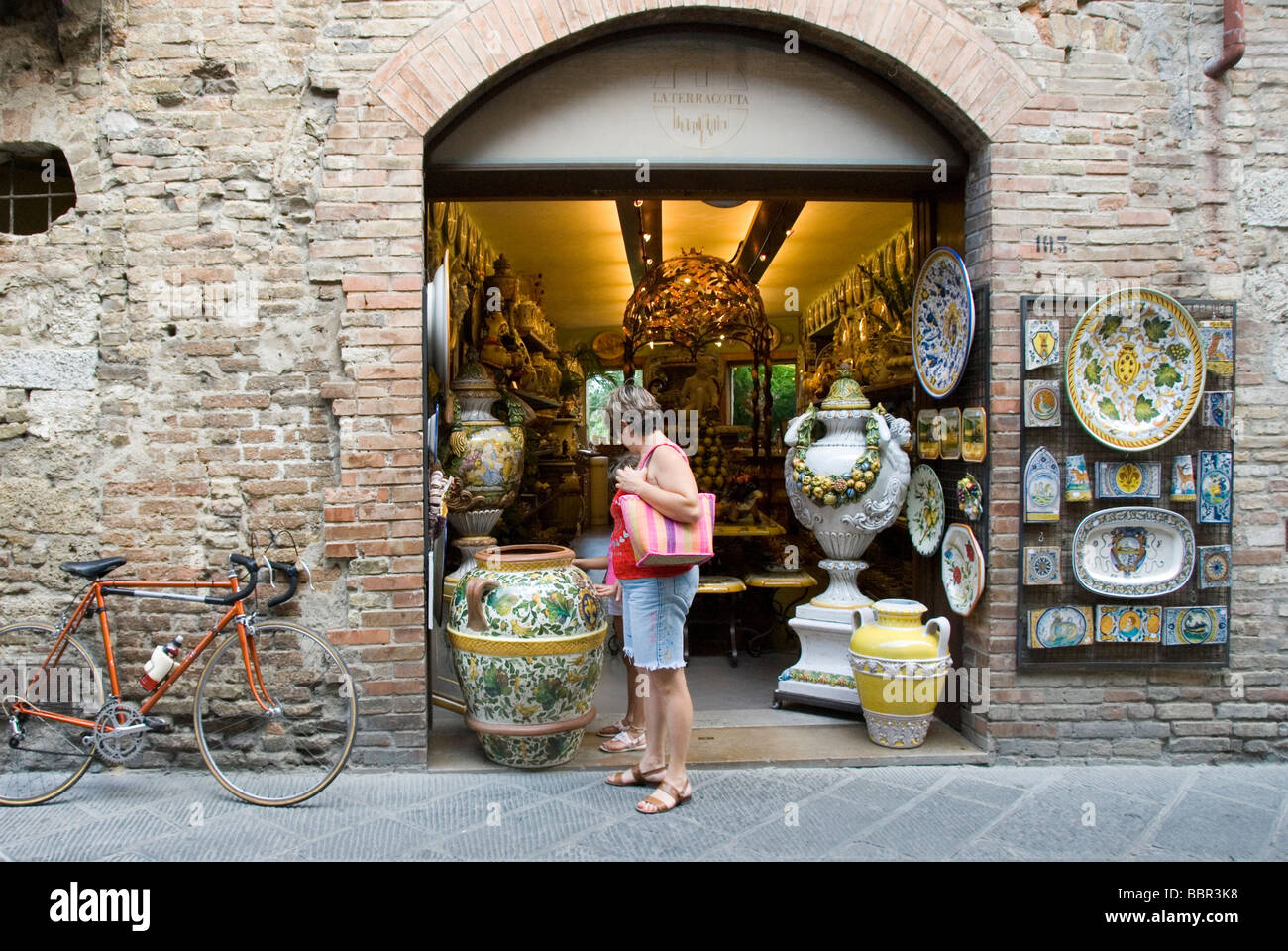 Woman tourist peruses majolica ceramic in San Gimignano Stock Photo