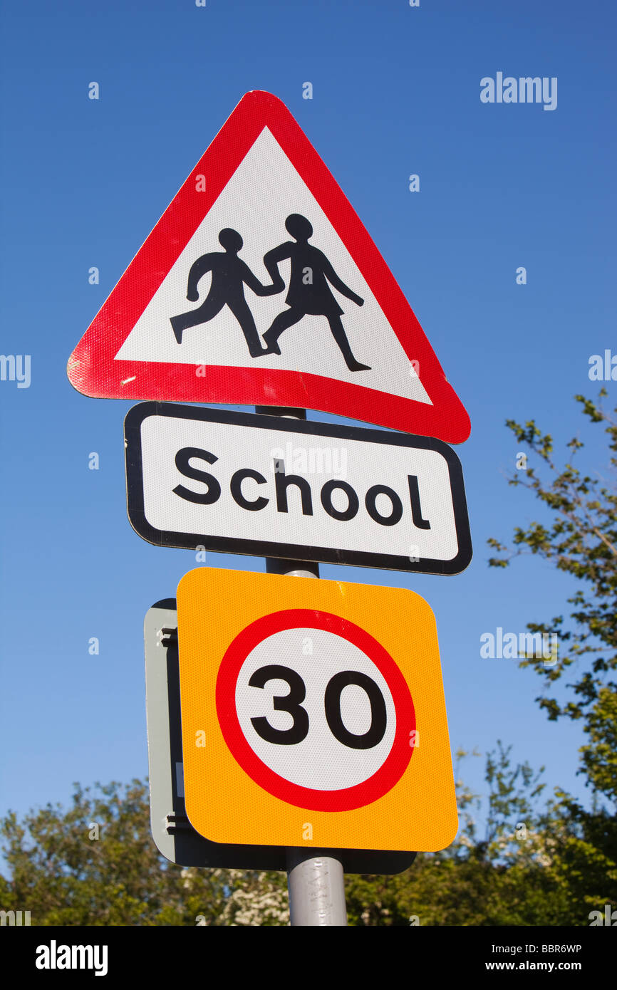 A school sign and speed limit sign in Berrynarbor Devon UK Stock Photo