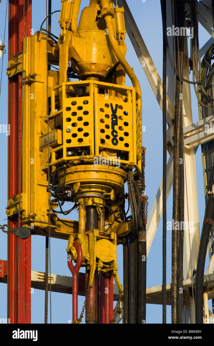 An oil rig drilling derrick showing detail of the Varco top drive assembly suspended at the 90 foot level. Stock Photo