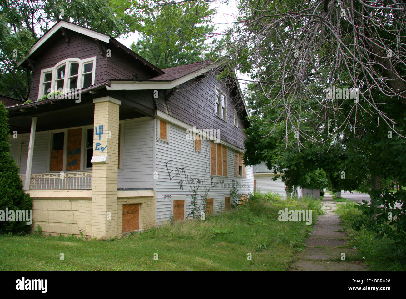 Boarded up house covered in gang markings and graffiti Detroit Michigan USA Stock Photo
