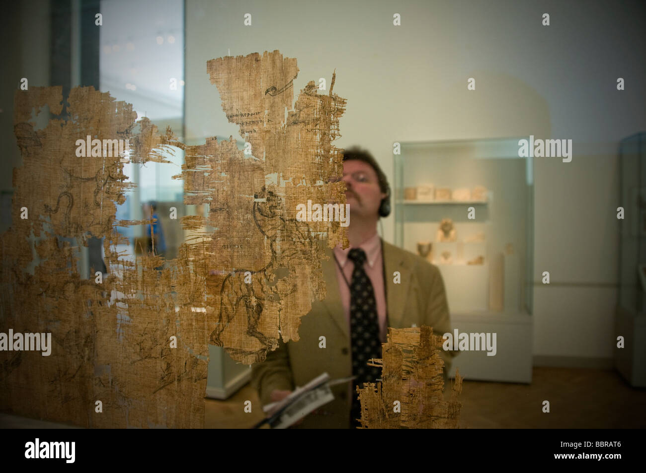 A visitor inspecting fragments of an ancient Egyptian papyrus part of Ancient Egyptian collection displayed in Altes Museum in Berlin Germany Stock Photo