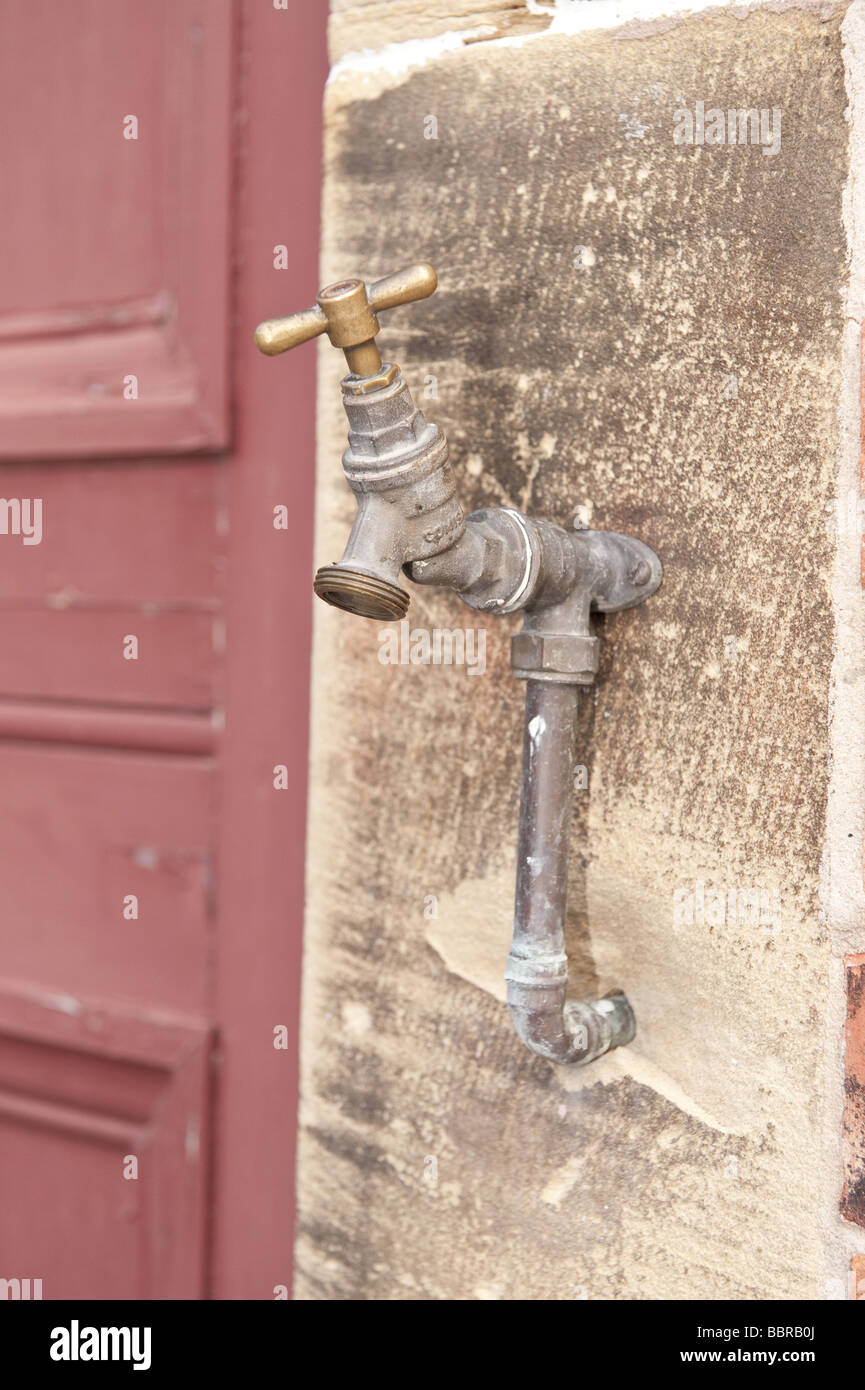 Brass external/outside water utility tap fitted to textured sandstone