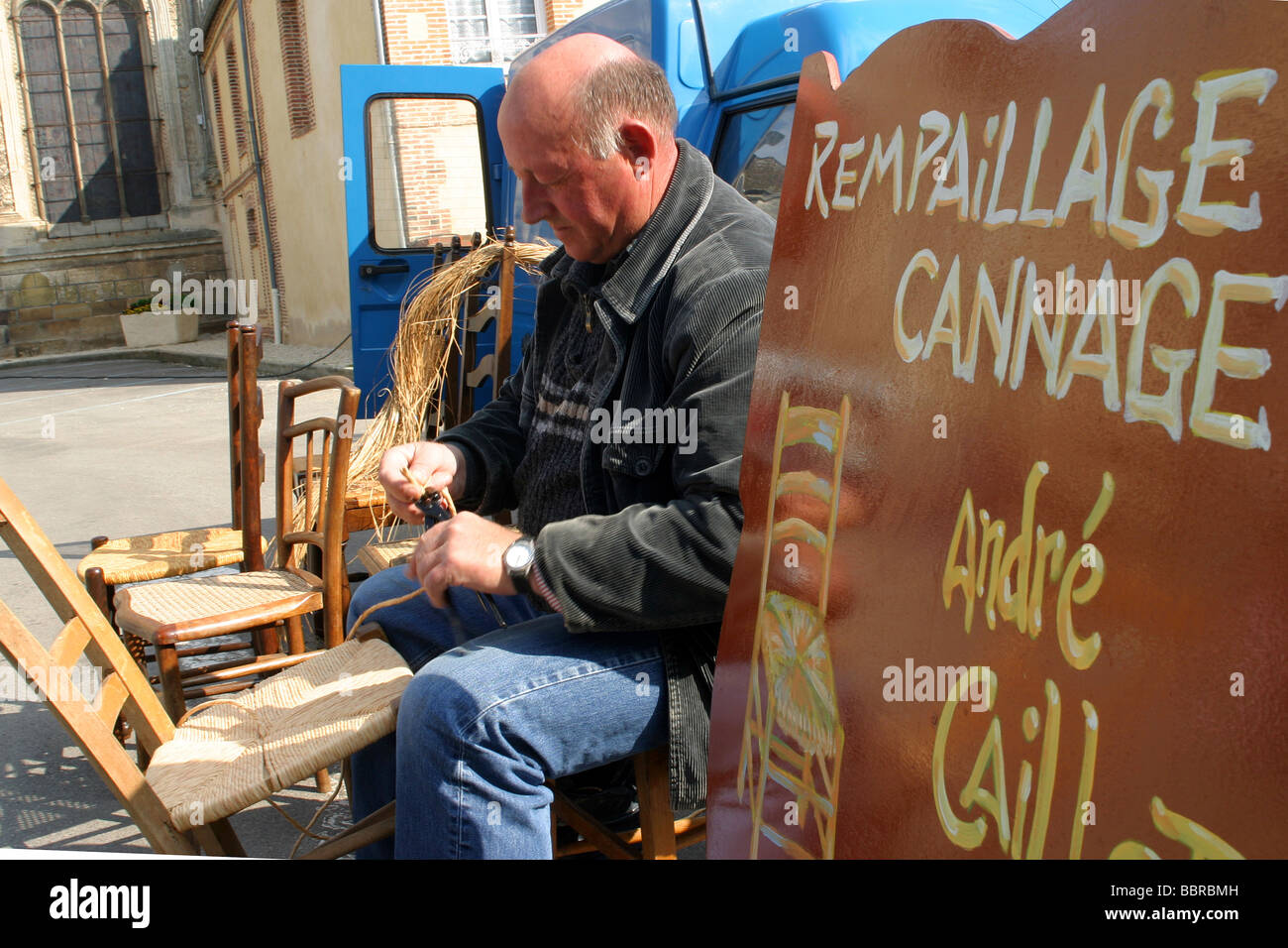 TRADITIONAL RESEATING AND CANING OF CHAIRS, FURNITURE RESTORATION, MARKET SQUARE, RUGLES, FRANCE Stock Photo