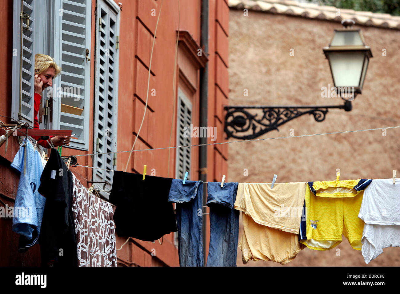 LAUNDRY HUNG OUT TO DRY BETWEEN TWO WINDOWS OVER A STREET, TRASTEVERE