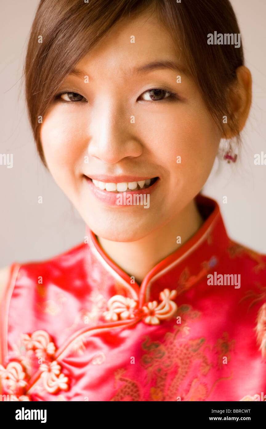 Young Chinese woman with silk dress Cheongsam with beautiful patterns, is a Chinese traditional clothes. Stock Photo