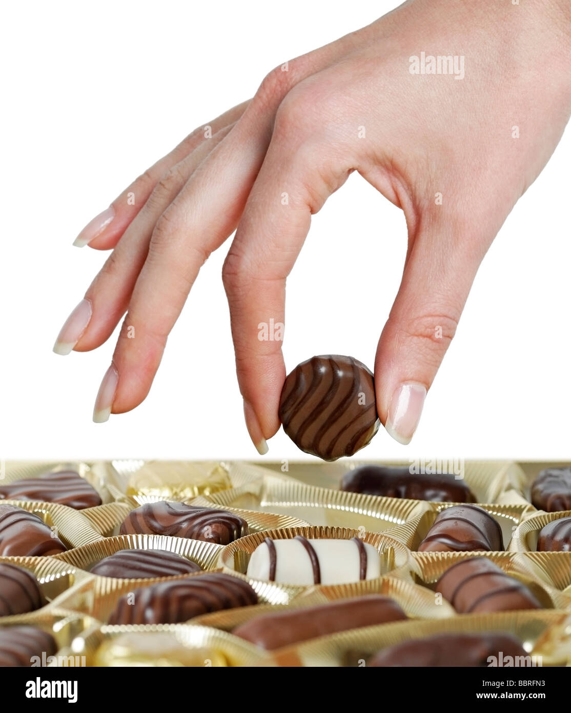 Woman Selecting a Truffle from a Box of Chocolates Stock Photo