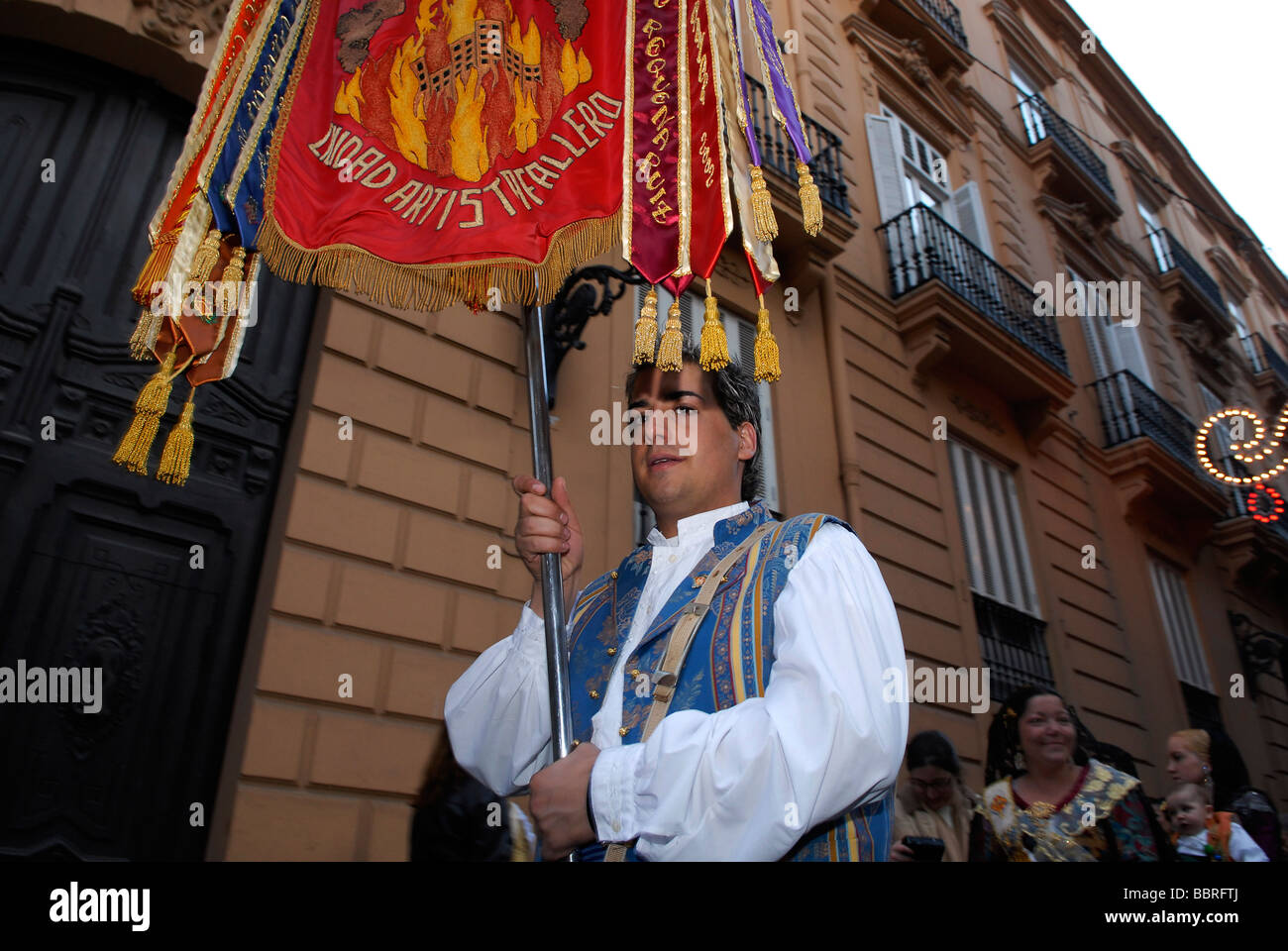 Falleras in traditional Valencian costume marching in the street during ...