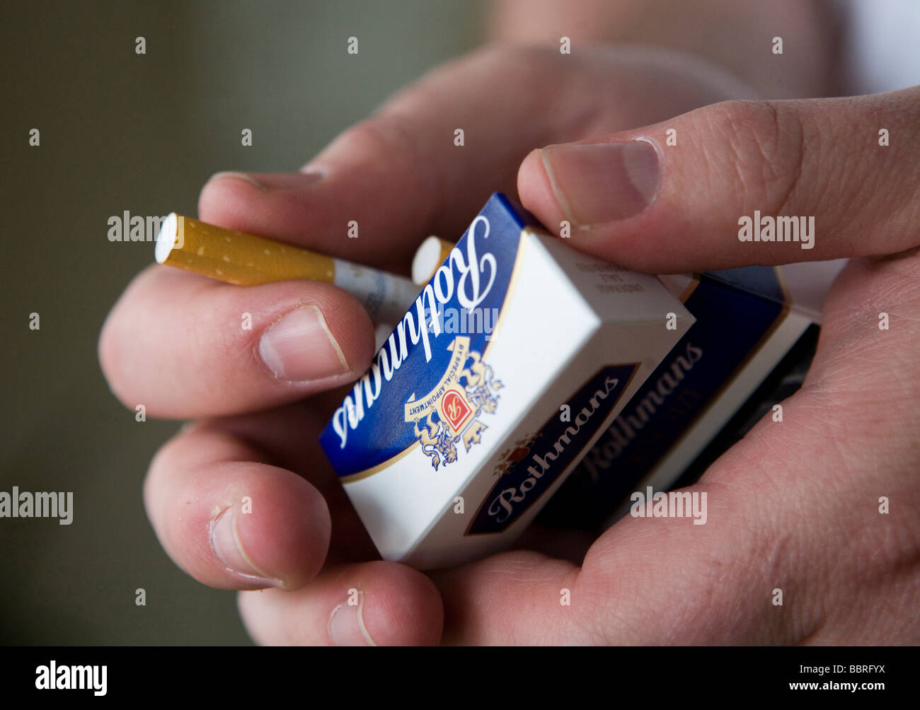 A smoker takes a Rothmans cigarette made by British American Tobacco from a packet Stock Photo