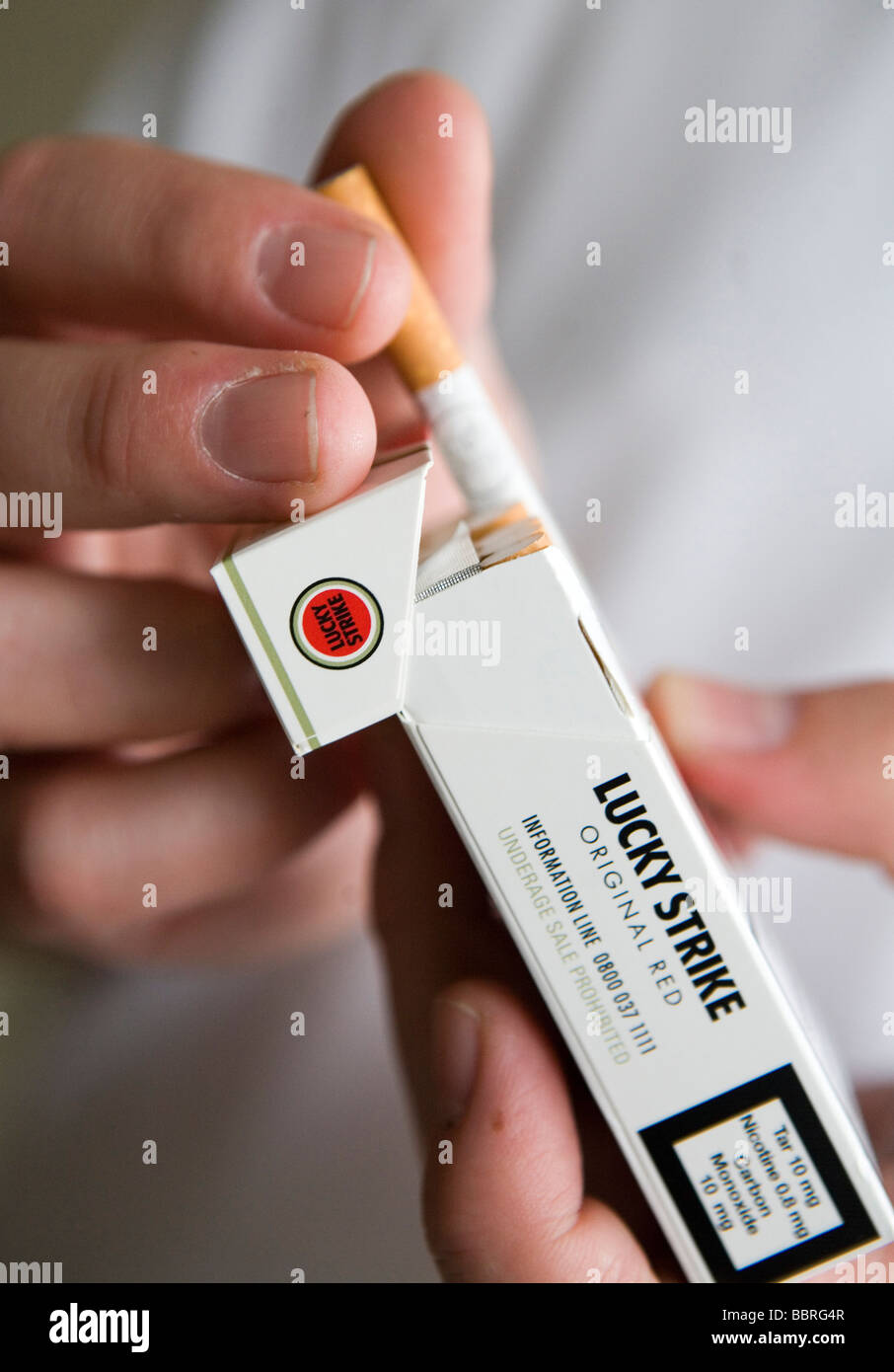 A smoker takes a Lucky Strike cigarette made by British American