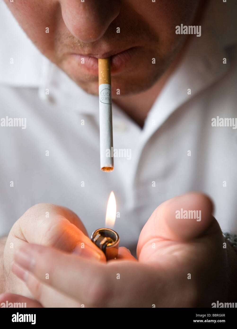 A smoker lights a Lucky Strike cigarette made by British American Tobacco Stock Photo