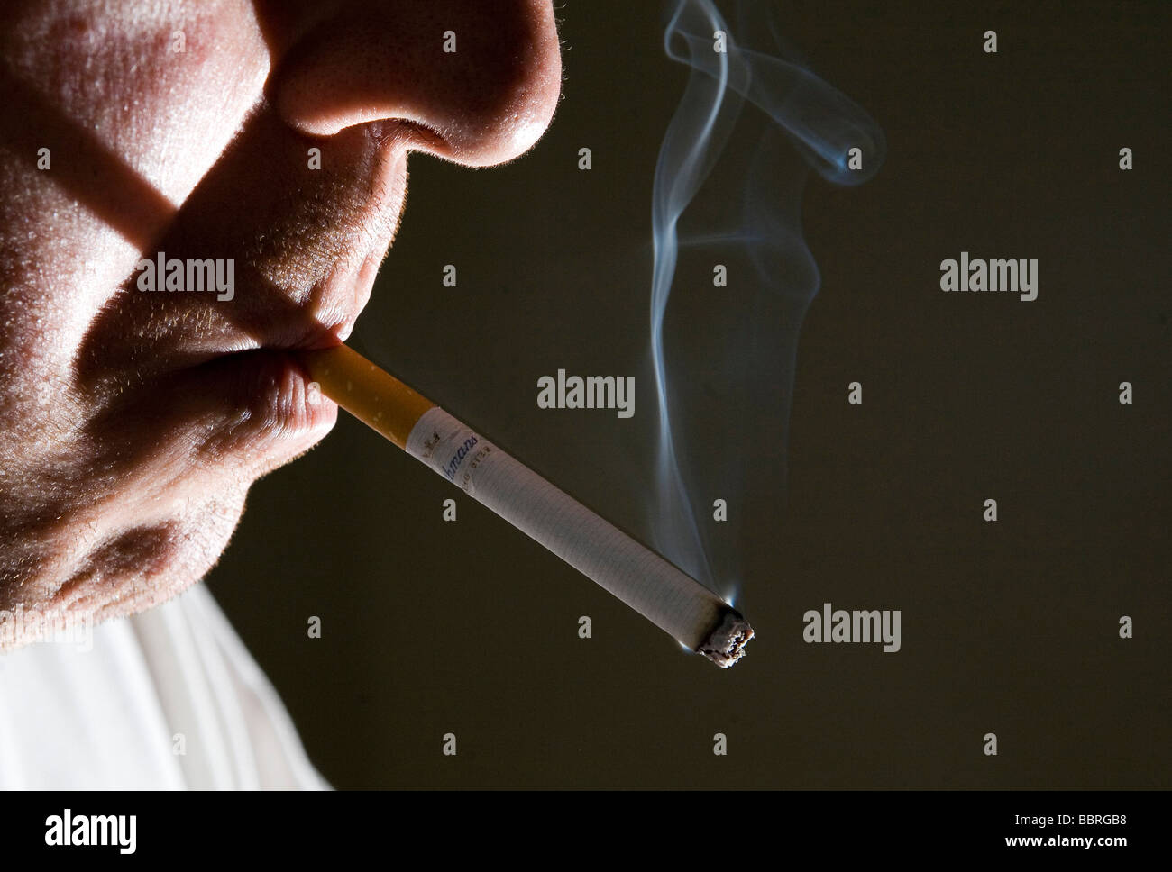A smoker smokes a Rothmans cigarette made by British American Tobacco Stock Photo