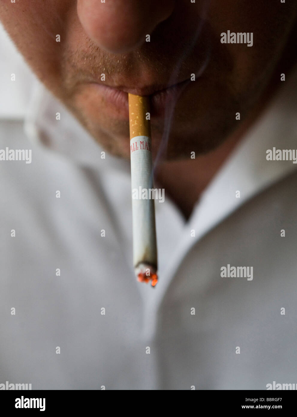A smoker smokes a Pall Mall cigarette made by British American Tobacco