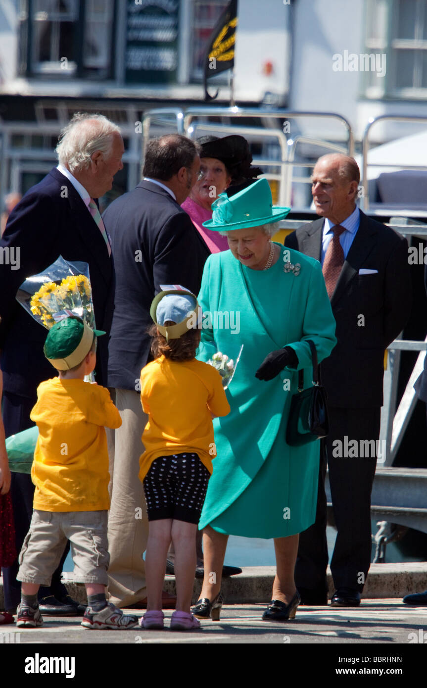 Queen Elizabeth II of England is given a bouquet of flowers by two children as she gets off a yacht in Weymouth Harbour, Dorset Stock Photo