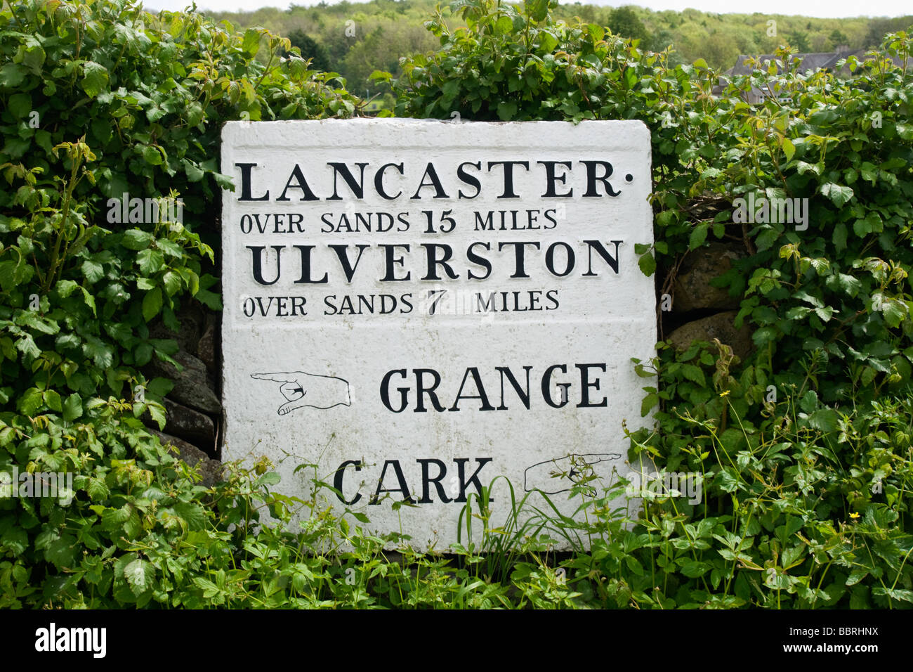 Milestone and direction sign at Cartmel in Cumbria. Stock Photo