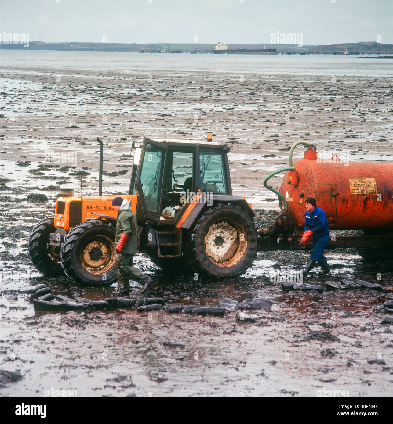 Tractor and bowser cleaning the oil from shoreline following the Sea Empress disaster Stock Photo