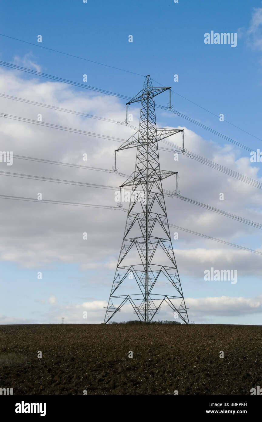 Single electricity pylon against blue sky with white fluffy clouds ...