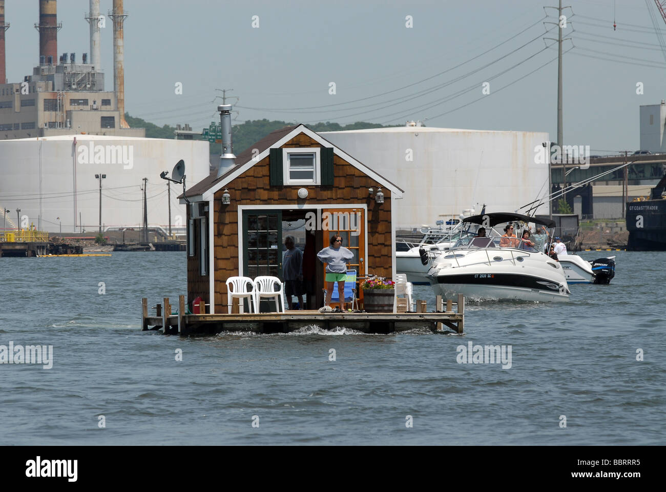 A houseboat motors through New Haven Harbor in Long Island Sound in New Haven Connecticut USA Stock Photo